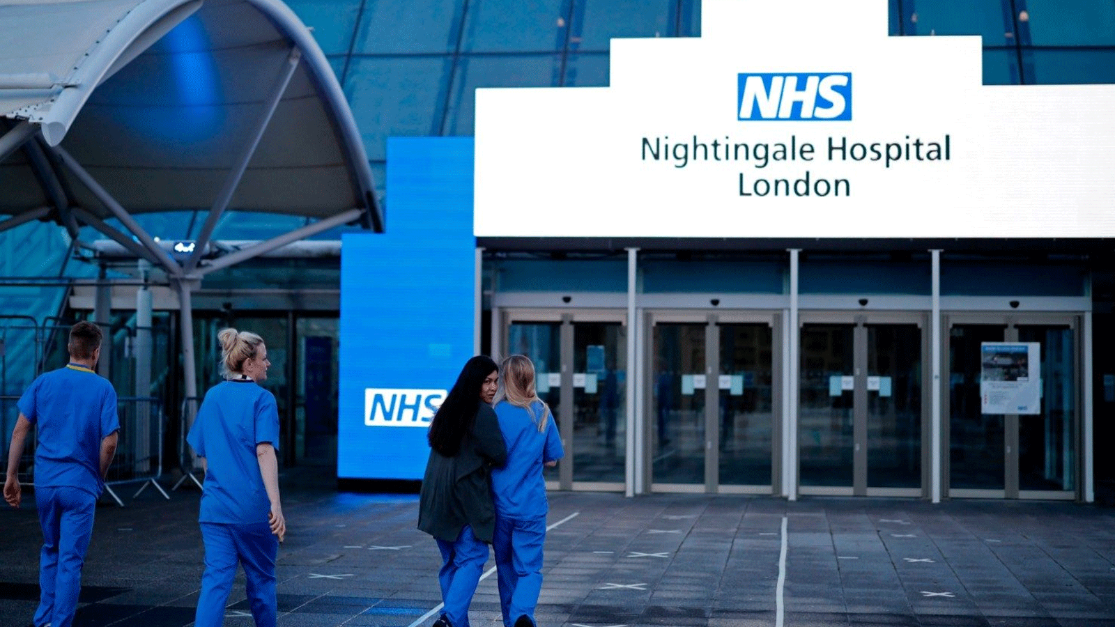 طاقم طبي من دائرة الصحة الوطنية البريطانية خارج مستشفى NHS Nightingale الميداني في لندن