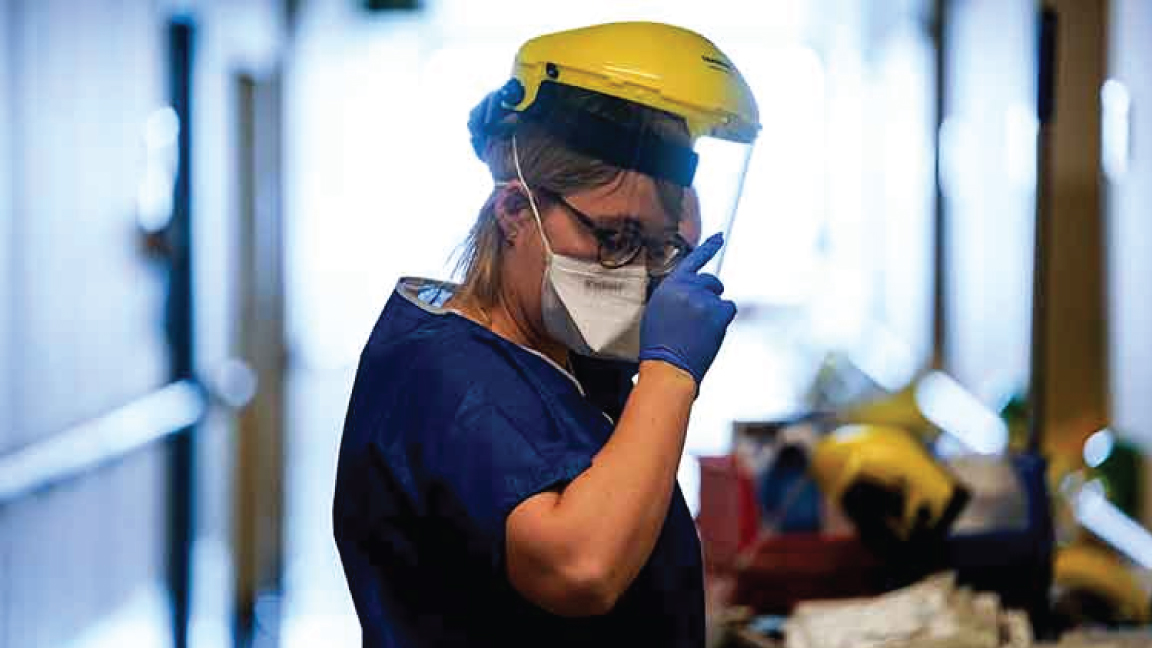 عامل طبي يرتدي قناعًا وقائيًا في بلجيكا أثناء الجائحة 