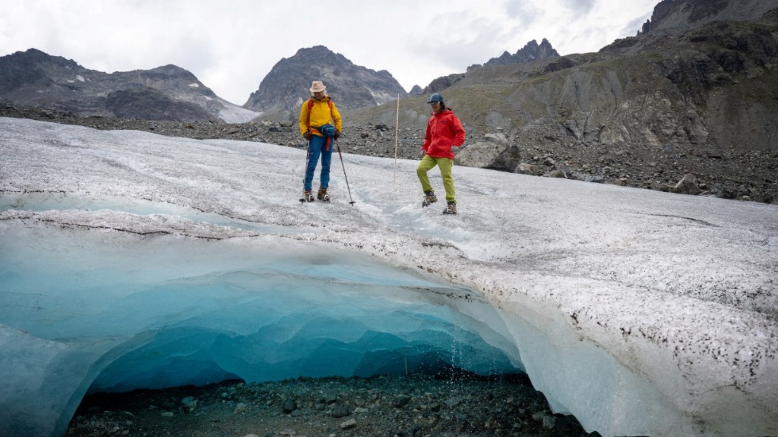 عالمتا الجليد أندريا فيشر (على اليسار) وفيوليتا لوريا من الأكاديمية النمساوية للعلوم يسيران على نهر جامتال الجليدي (جامتالفيرنر) بالقرب من جالتوير، تيرول، النمسا في 20 يوليو 2022