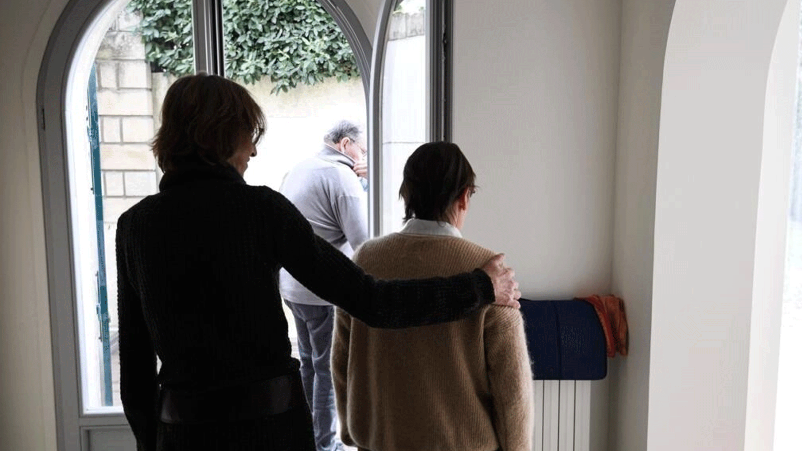 مقدمة رعاية تساعد مقيمة مسنة مصابة بمرض الزهايمر في مؤسسة L'Hay-les- Roses في ضواحي باريس