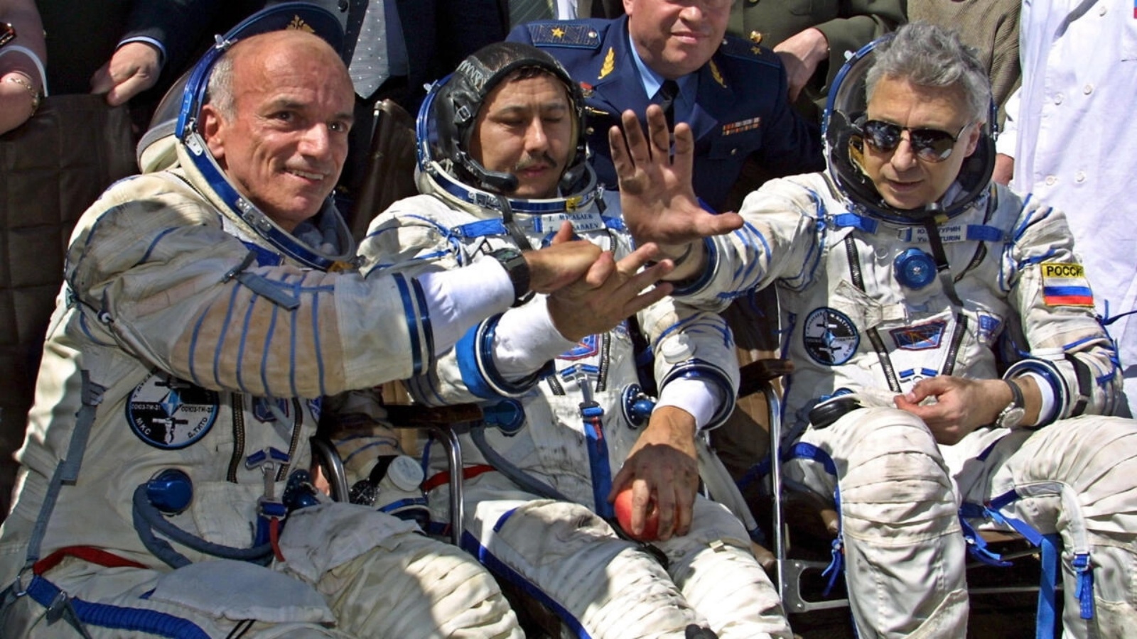 سائح الفضاء الأميركي دنيس تيتو (يسار) يصافح أفراد طاقمه بعد هبوطهم بالقرب من بلدة أركاليك الكازاخستانية على بعد 300 كيلومتر من آستانا، 06 مايو 2001