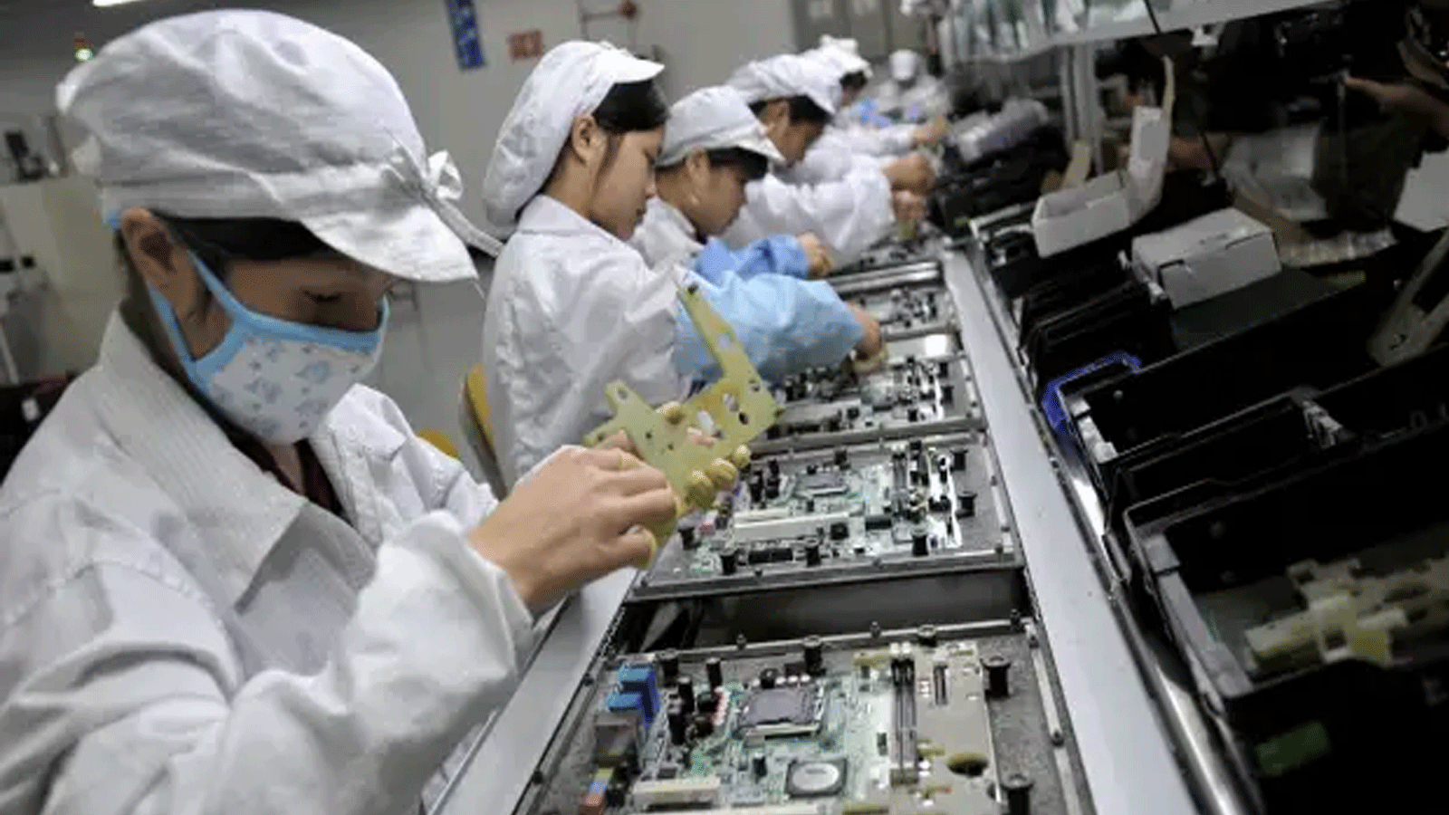 عمال صينيون يجمعون المكونات الإلكترونية في مصنع التكنولوجيا التايوانية العملاقة فوكسكون في شنتشن،الصين.