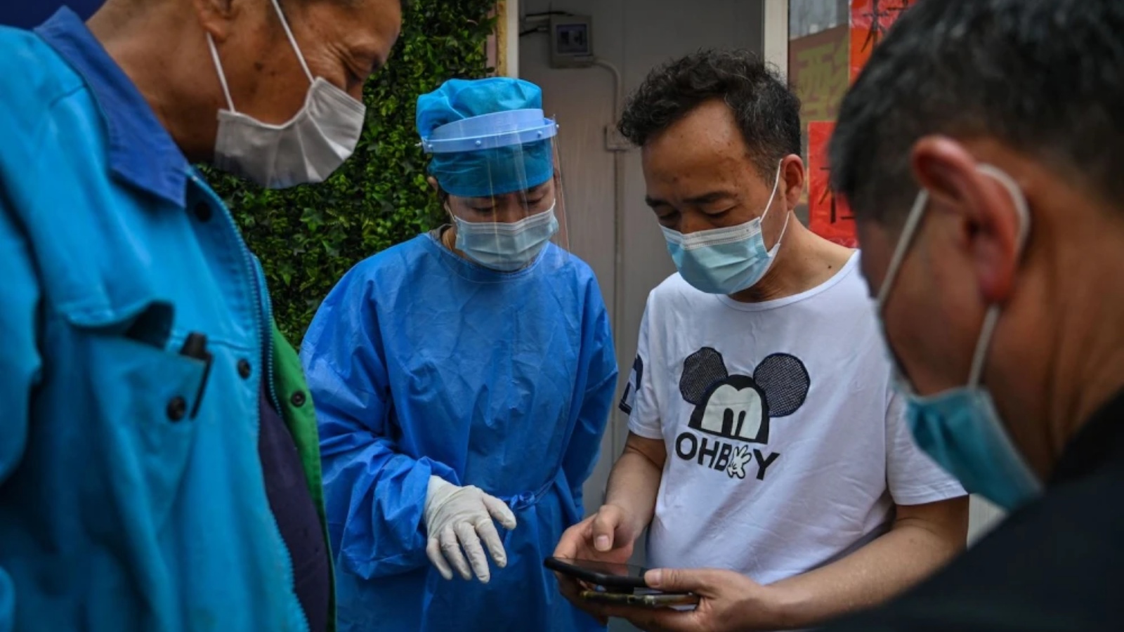 عامل صحي يساعد الناس في الحصول على رمز ليتمكنوا من اختبار COVID-19 في شنغهاي في 14 مارس