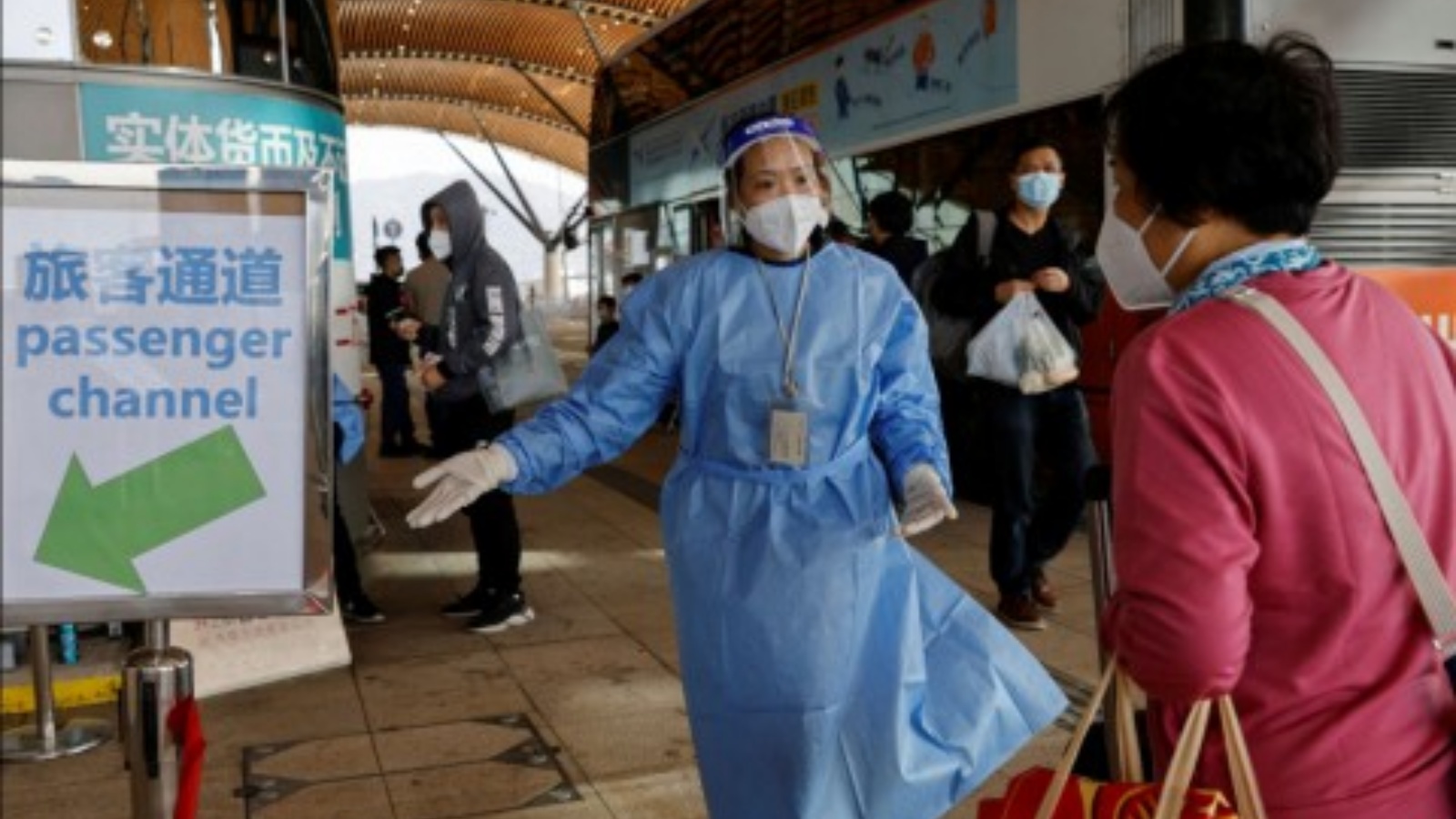 عاملة صحة ترشد مسافرة في الحدود بين الصين وهونغ كونغ