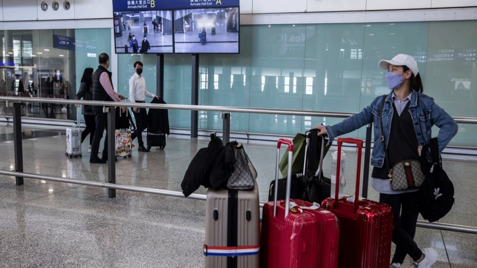  امرأة تنتظر في صالة الوصول بمطار هونغ كونغ الدولي في هونغ كونغ في 8 كانون الأول\ديسمبر 2022.