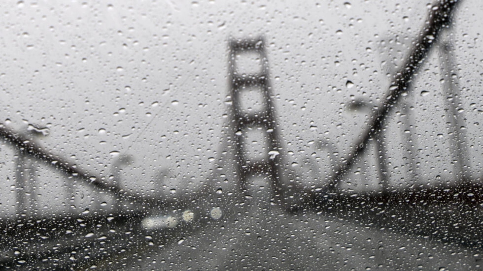 جسر غولدن غايت في صورة ملتقطة من وراء زجاج سيارة أمامي تغطيه الأمطار في سان فرانسيسكو في كاليفورنيا في الرابع من يناير 2023 