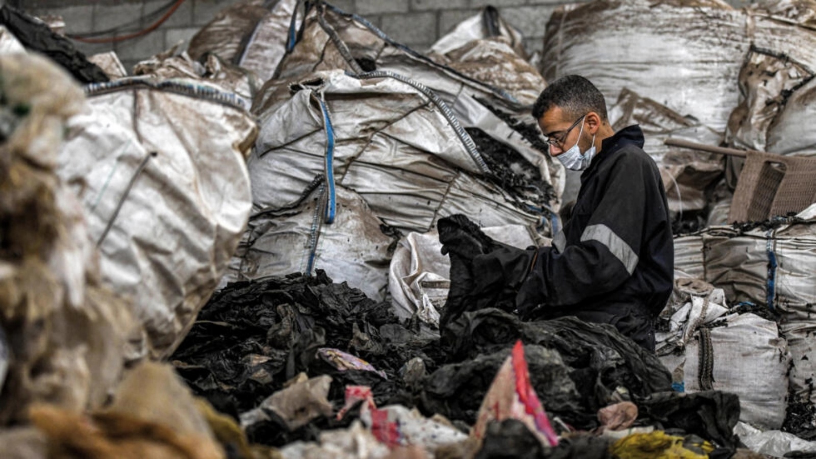 عامل يفرز النفايات البلاستيكية في مصنع شركة 