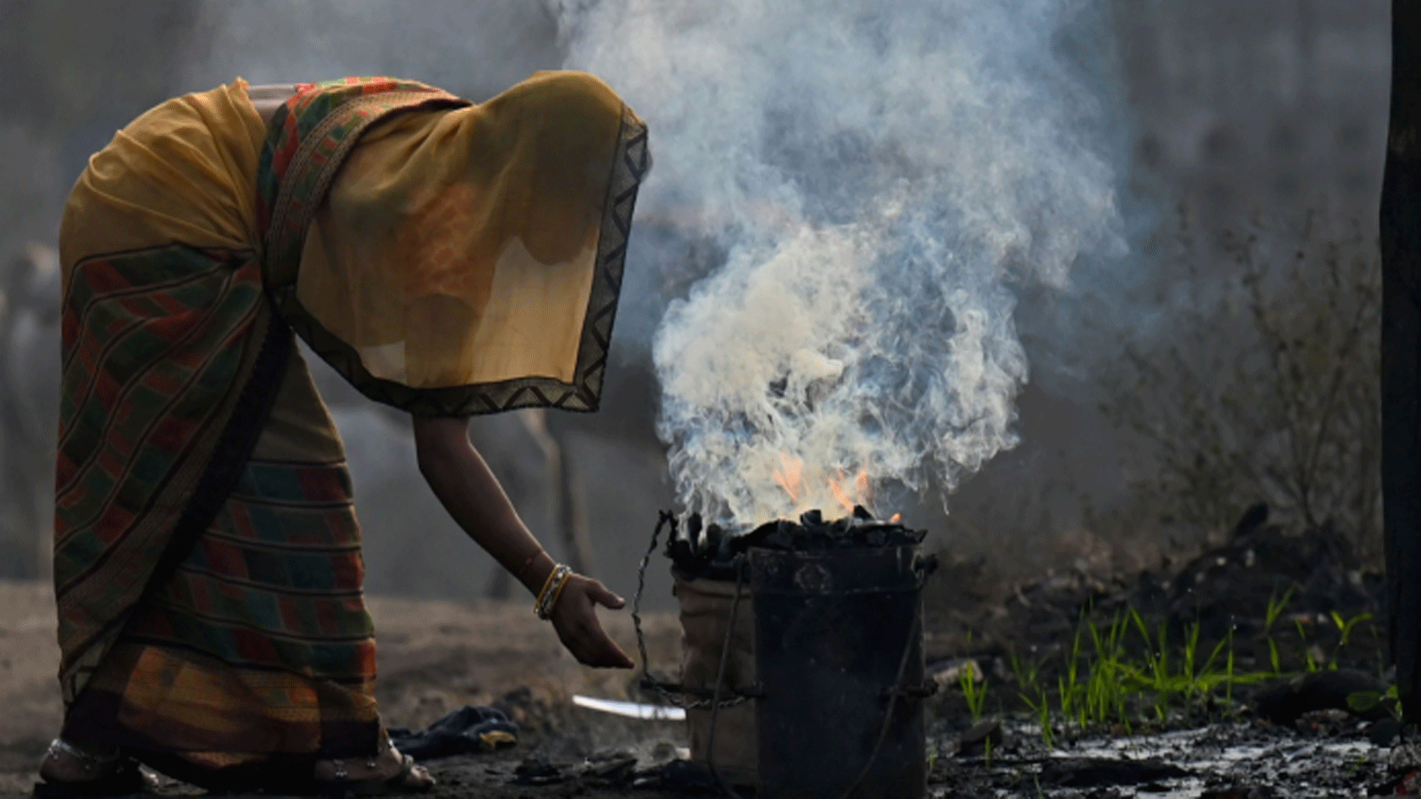 صورة توضيحية لامرأة تحرق الفحم للاستخدام المنزلي في سينجرولي(Singrauli) بولاية ماديا براديش(Madhya Pradesh) في الهند