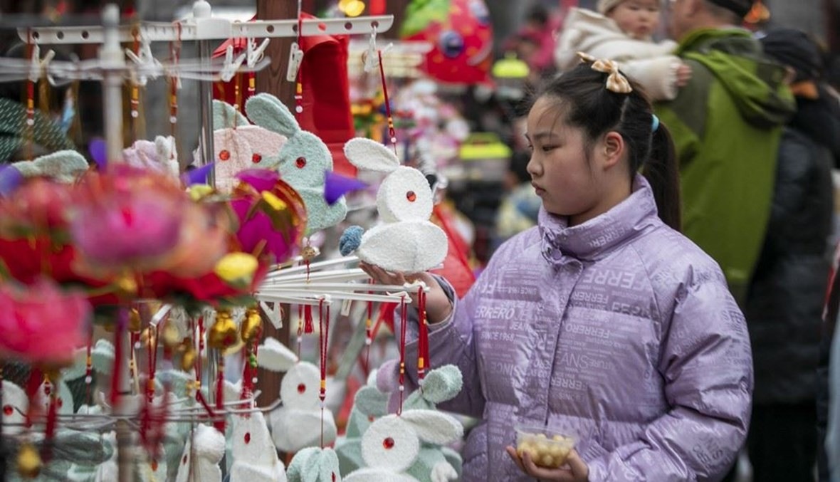 أشخاص يختارون الفوانيس خلال مهرجان المصابيح في تايتشو بمقاطعة جيانغسو شرق الصين في 5 فبراير 2023
