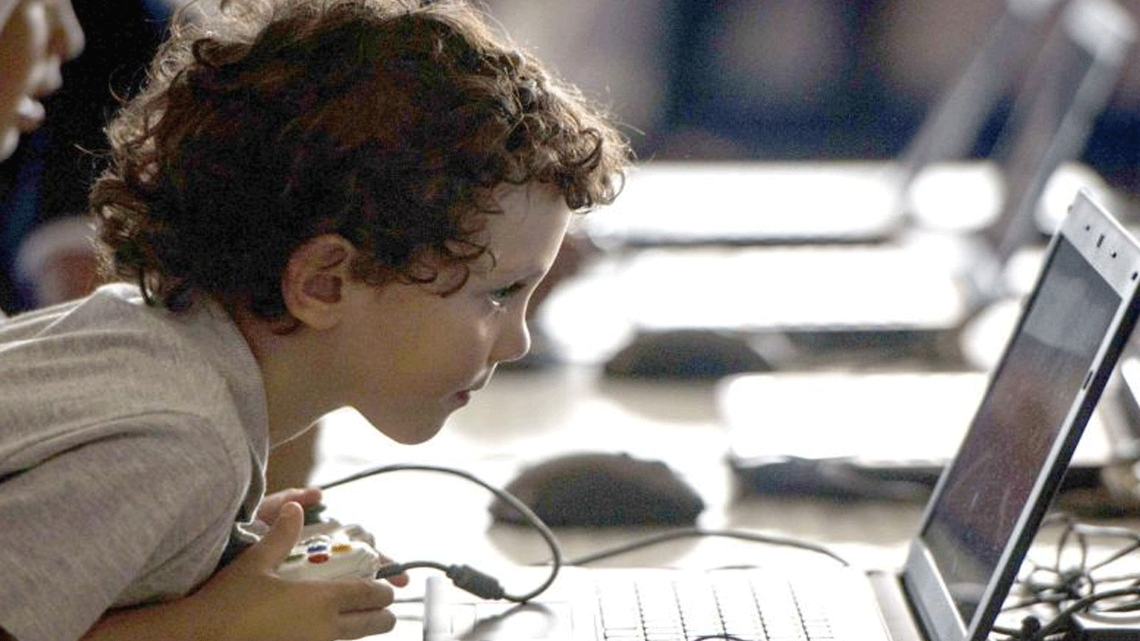 صورة توضيحية لطفل يلعب على الكومبيوتر متأخراً على موعد نومه