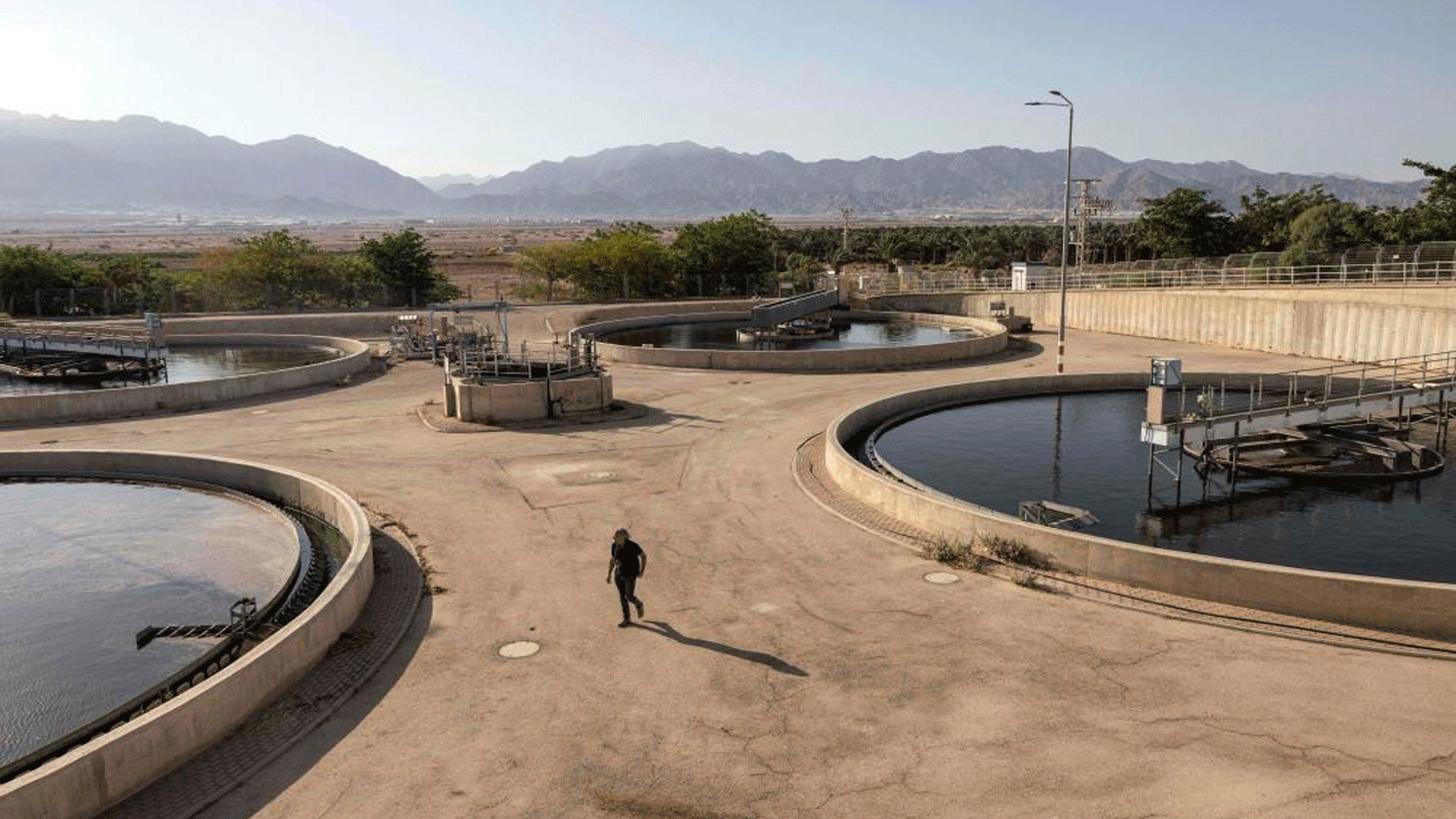 أريك أشكنازي، كبير المهندسين في محطة معالجة مياه الصرف الصحي في عين نتافيم، يسير بين أحواض تنقية المياه في المنشأة الواقعة في مدينة إيلات الساحلية جنوب إسرائيل. 13 يوليو (تموز) 2023.