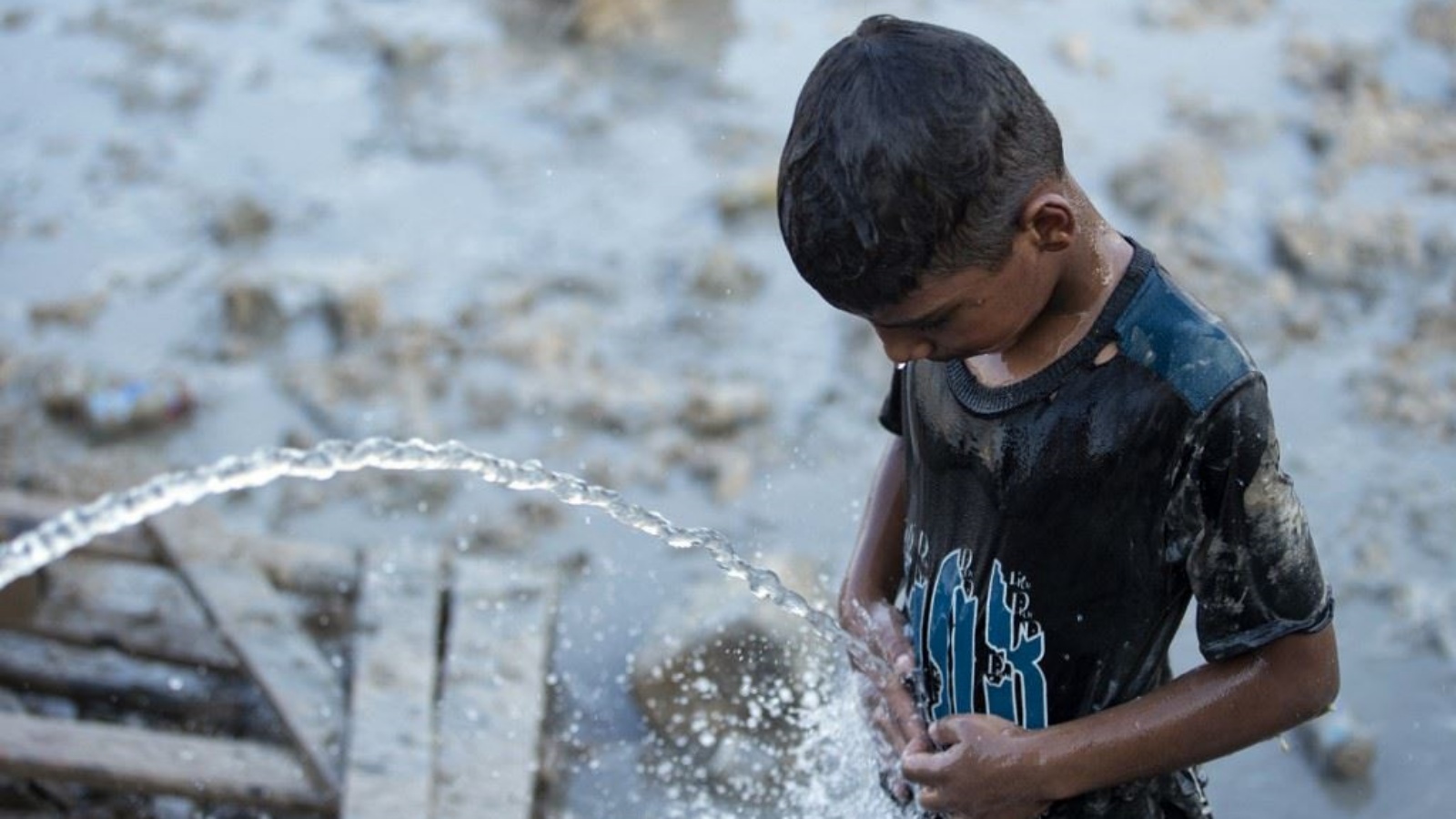 طفل يبرد جسمه بالماء في البصرة