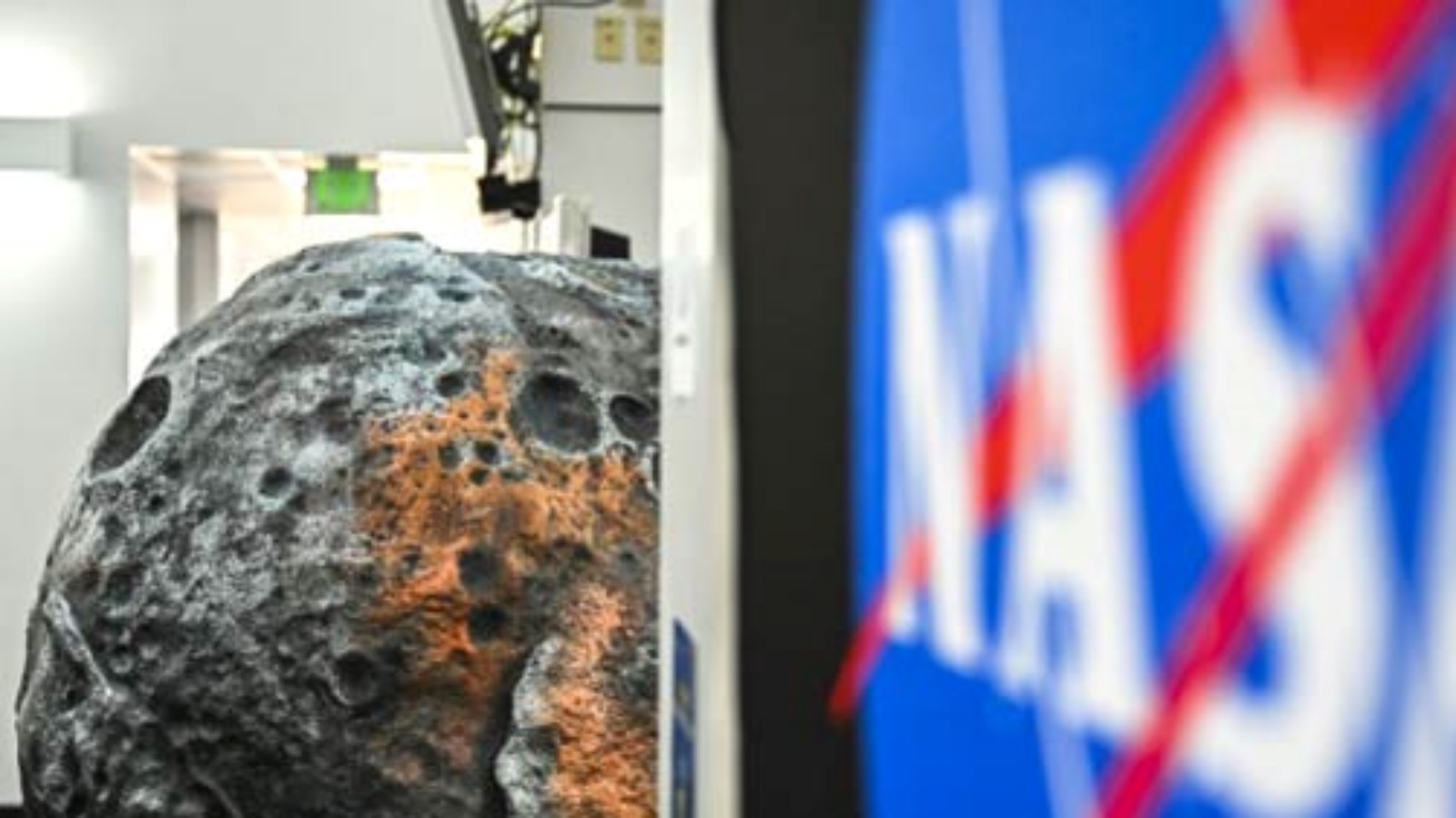 شعار ناسا أمام مجسّم لكويكب سايكي في مركز كينيدي الفضائي في فلوريدا، بتاريخ العاشر من أكتوبر 2023.