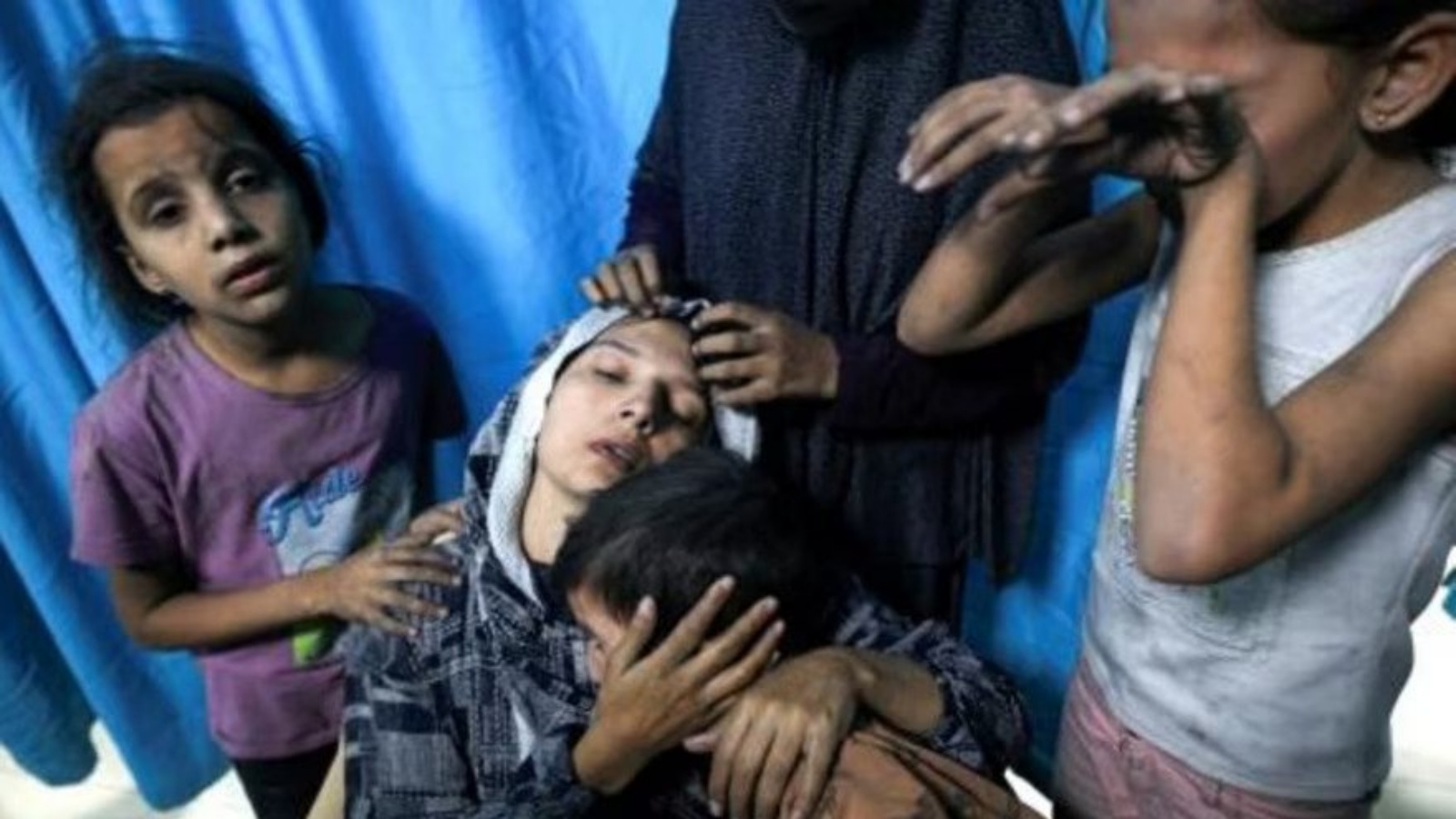 مصابة فلسطينية محاطة بأطفالها لدى وصولهم إلى مستشفى ناصر في خان يونس في جنوب قطاع غزة في 13 نوفمبر 2023