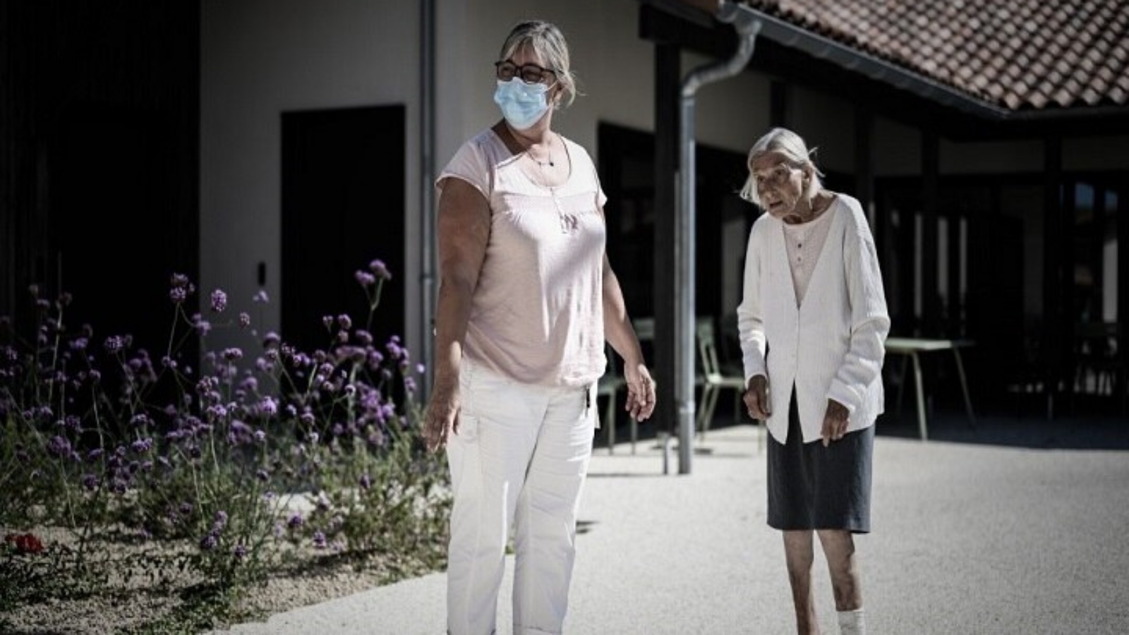 مريضة بألزهايمر (على اليمين) ومتطوعة أثناء نزهة في موقع قرية لانديس للألزهايمر المخصص لمرضى ألزهايمر في داكس، جنوب غرب فرنسا