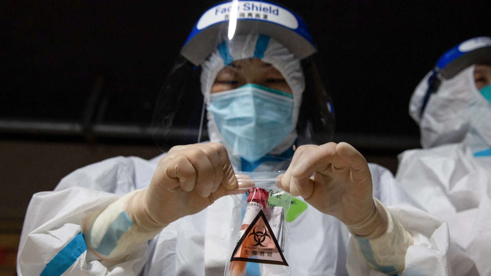 عامل طبي يجمع عينة من اختبار الحمض النووي لفيروس كوفيد-19 في نانجينغ، الصين