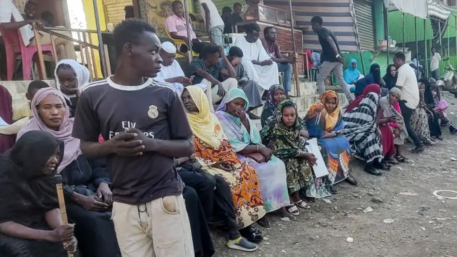 أشخاص من ولايتي الخرطوم والجزيرة، نزحوا بسبب الصراع المستمر في السودان بين الجيش وقوات الدعم السريع، ينتظرون تلقي المساعدات من منظمة خيرية في القضارف. 30 كانون الأول (ديسمبر) 2023