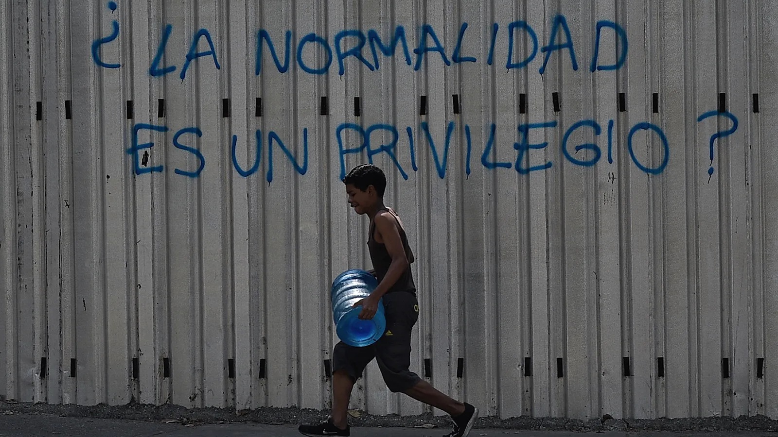 صبي يمر أمام جدارية كتب عليها “هل العدالة امتياز؟” في كراكاس في 31 آذار (مارس)