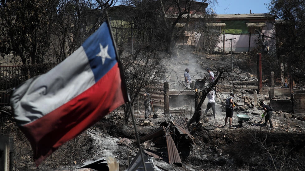 العلم التشيلي يرفرف فوق أنقاض منزل التهمته النيران في فيلا إندبندنسيا في فالباريسو في تشيلي في 5 شباط/فبراير 2024
