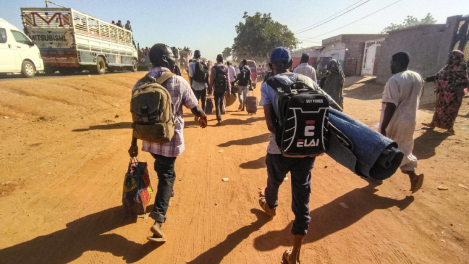 نازحون سودانيون يسيرون على طريق في ود مدني عاصمة ولاية الجزيرة