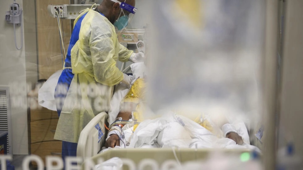 ممرضات يعتنين بمصاب بكوفيد-19 في قسم الرعاية المركزة بمستشفى في لوس أنجليس بولاية كاليفورنيا بتاريخ 6 كانون الثاني/يناير 2021