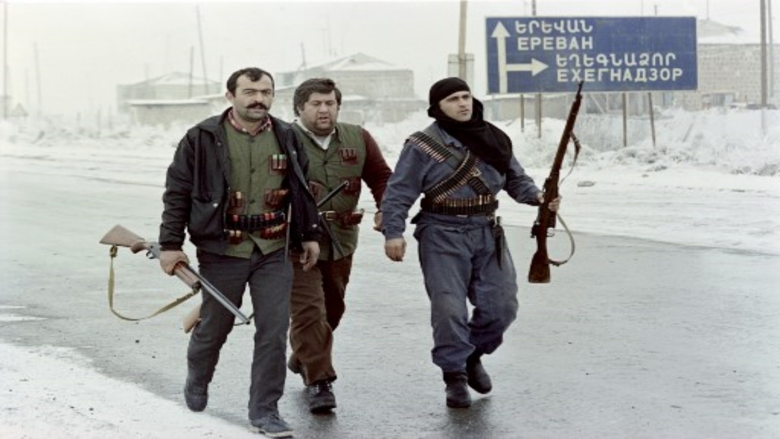 مقاتلون أرمن مسلحون يمرون بجانب لوحة تشير إلى يريفان وهم يقومون بدوريات على طول الحدود مع جيب ناخيتشيفان الأذربيجاني