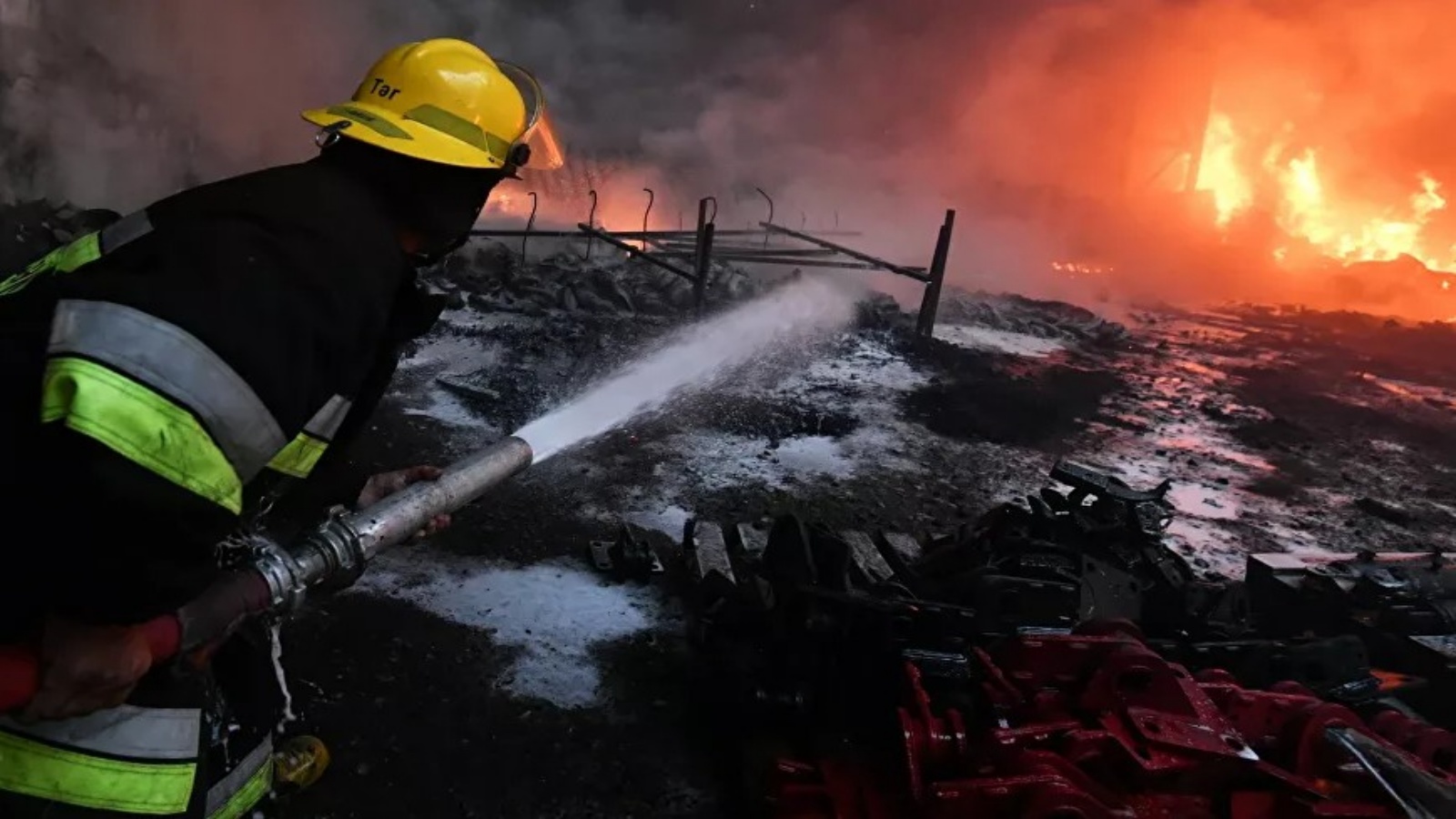عامل اطفاء في موقع حريق نتيجة قصف في النزاع الأرميني الأذري