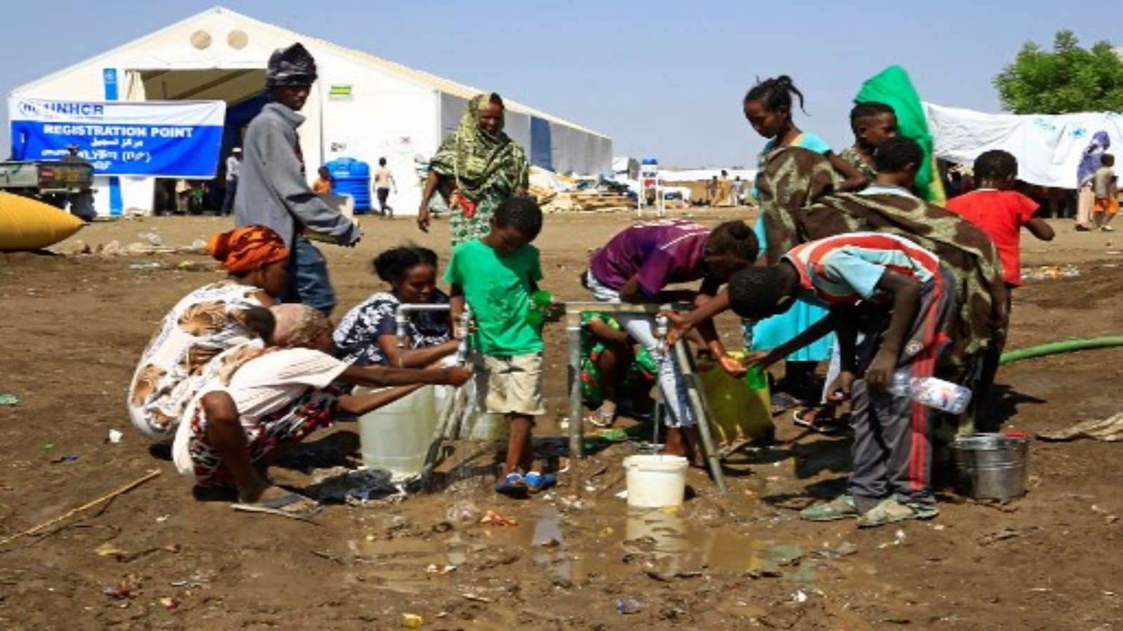 لاجئون اثيوبيون فروا من صراع تيغراي يملأون الزجاجات والحاويات بالمياه بعد وصولهم إلى مركز عبور في بلدة هامداييت الحدودية السودانية في 27 نوفمبر 2020