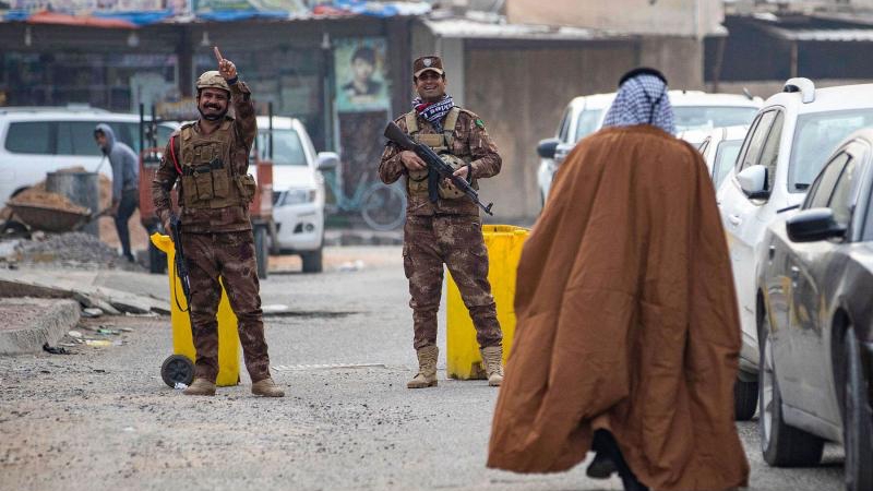 فردان من قوات الأمن العراقية يحرسان مركز اقتراع في البصرة، خلال أول انتخابات لمجالس المحافظات في عقد من الزمان، في 18 ديسمبر 2023