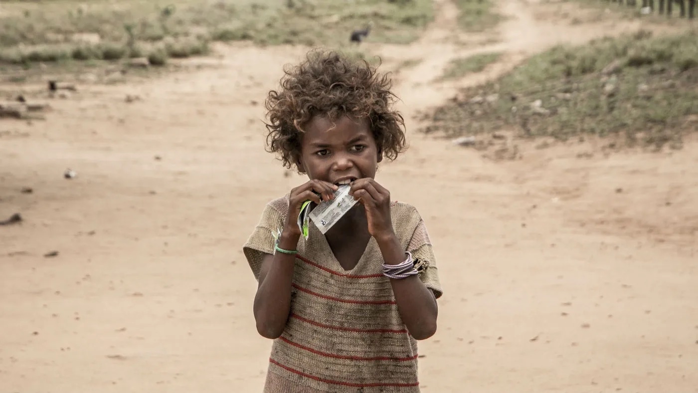 فتاة في مدغشقر تتناول مكملاً غذائياً يوزعه برنامج الأغذية العالمي التابع للأمم المتحدة