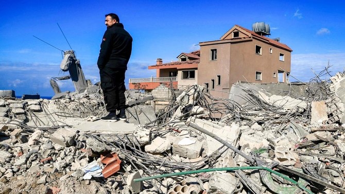 رجل يقف وسط أنقاض المباني المدمرة بعد ضربات إسرائيلية استهدفت بلدة الناقورة في جنوب لبنان في 4 كانون الثاني (يناير) 2024