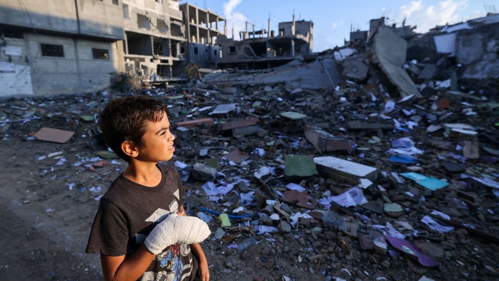 الفتى الفلسطيني المصاب محمد صوفي، 12 عامًا، يتفحص المباني المدمرة بالقرب من منزله في مخيم رفح، في 16 تشرين الأول (أكتوبر) 2023