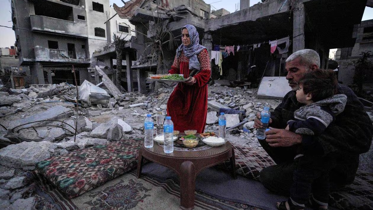 عائلة فلسطينية تتناول الإفطار وسط خرائب غزة في أول أيام شهر رمضان