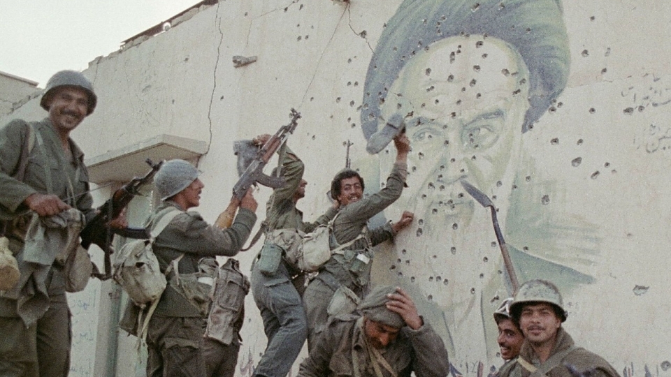 جنود عراقيون أمام جدارية للخميني مزقها الرصاص في 20 نيسان (أبريل) 1988