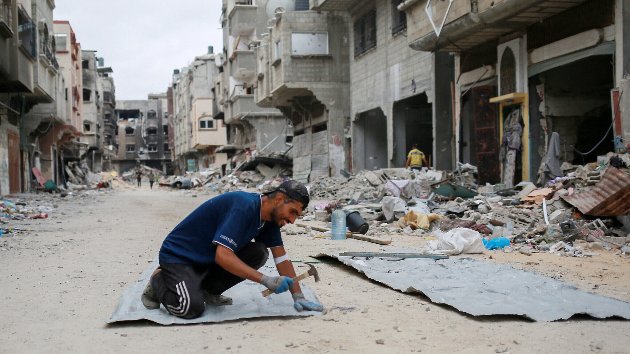 فلسطيني يبني مأوى للمبيت وسط ركام أبنية مدمرة في خان يونس في قطاع غزة في الثاني من أيار (مايو) 2024