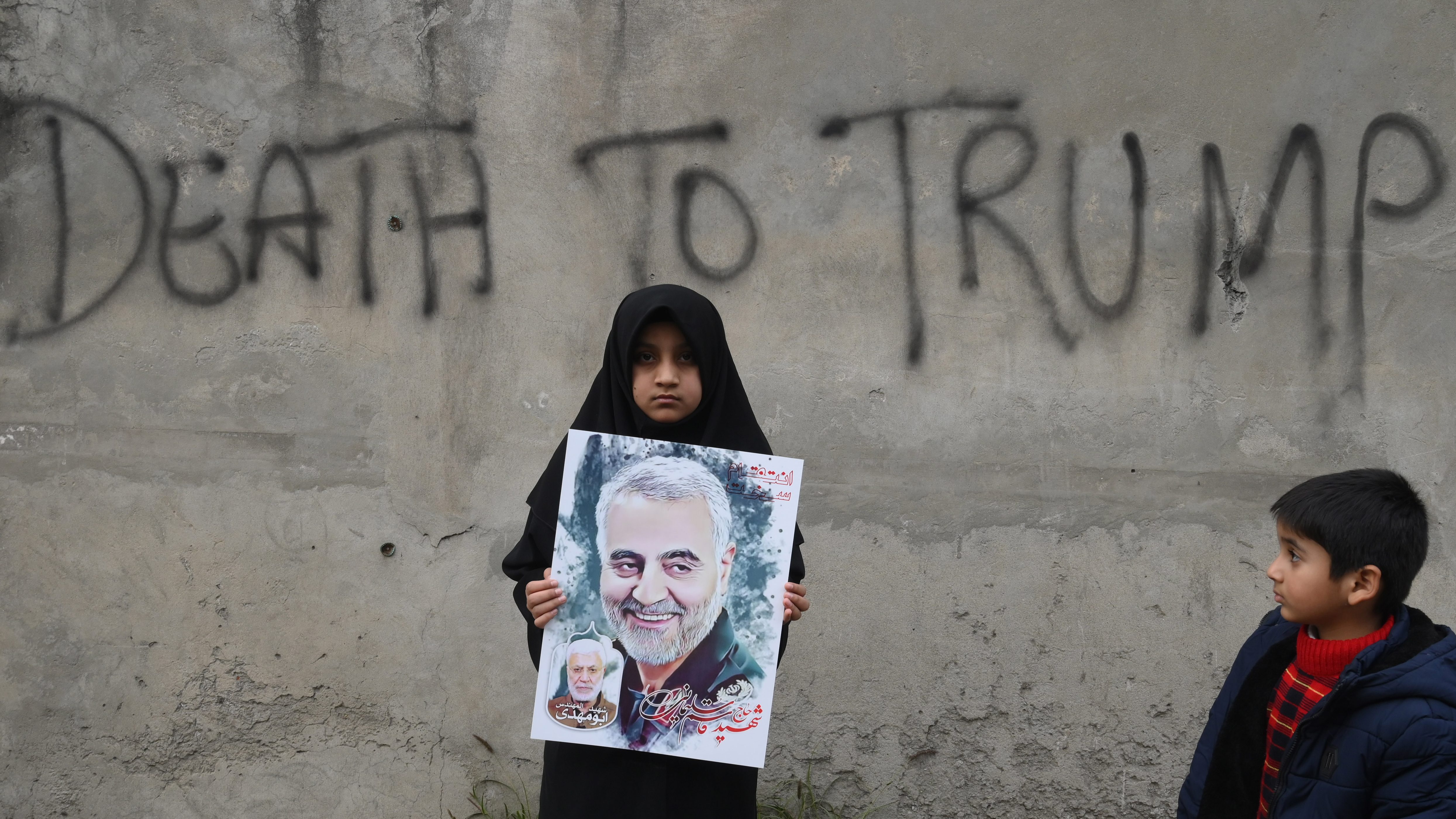 صورة أرشيفية لطفلة إيرانية تحمل صورة قاسم سليماني وخلفها يظهر شعاراً يقول 
