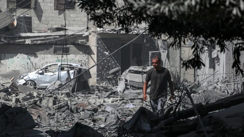 فلسطيني وسط أنقاض ودمار بفعل قصف إسرائيلي على مخيم النصيرات في قطاع غزة