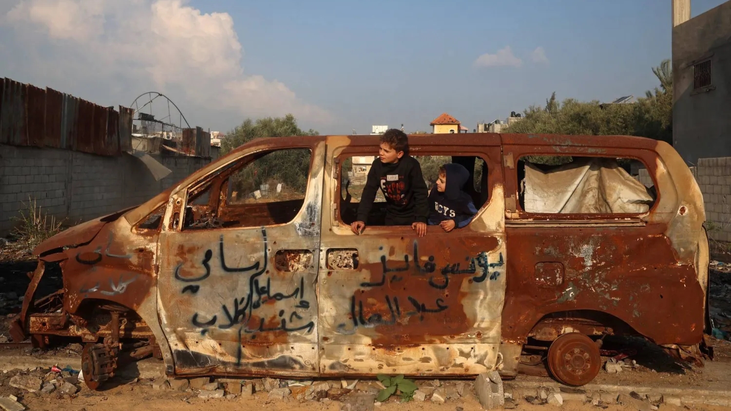 صبي فلسطيني يلعب داخل سيارة دمرتها غارة جوية إسرائيلية في مدينة غزة السبت