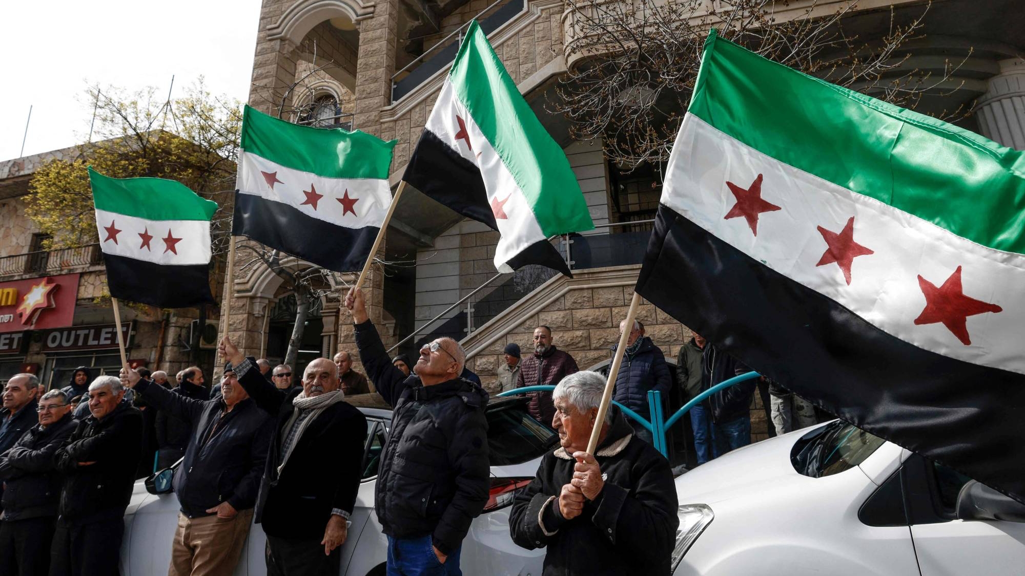 دروز من قرية مجدل شمس في مرتفعات الجولان التي ضمتها إسرائيل يلوحون بالأعلام السورية في أثناء مشاركتهم في مظاهرة يوم 14 فبراير في الذكرى الـ43 على ضم الهضبة الاستراتيجية التي احتلتها إسرائيل من سوريا خلال حرب 1967