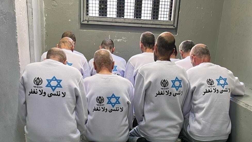 ارتدى الأسرى ملابس بيضاء تحمل نجمة داود بجانب رمز إدارة السجون وتحتهما عبارة 