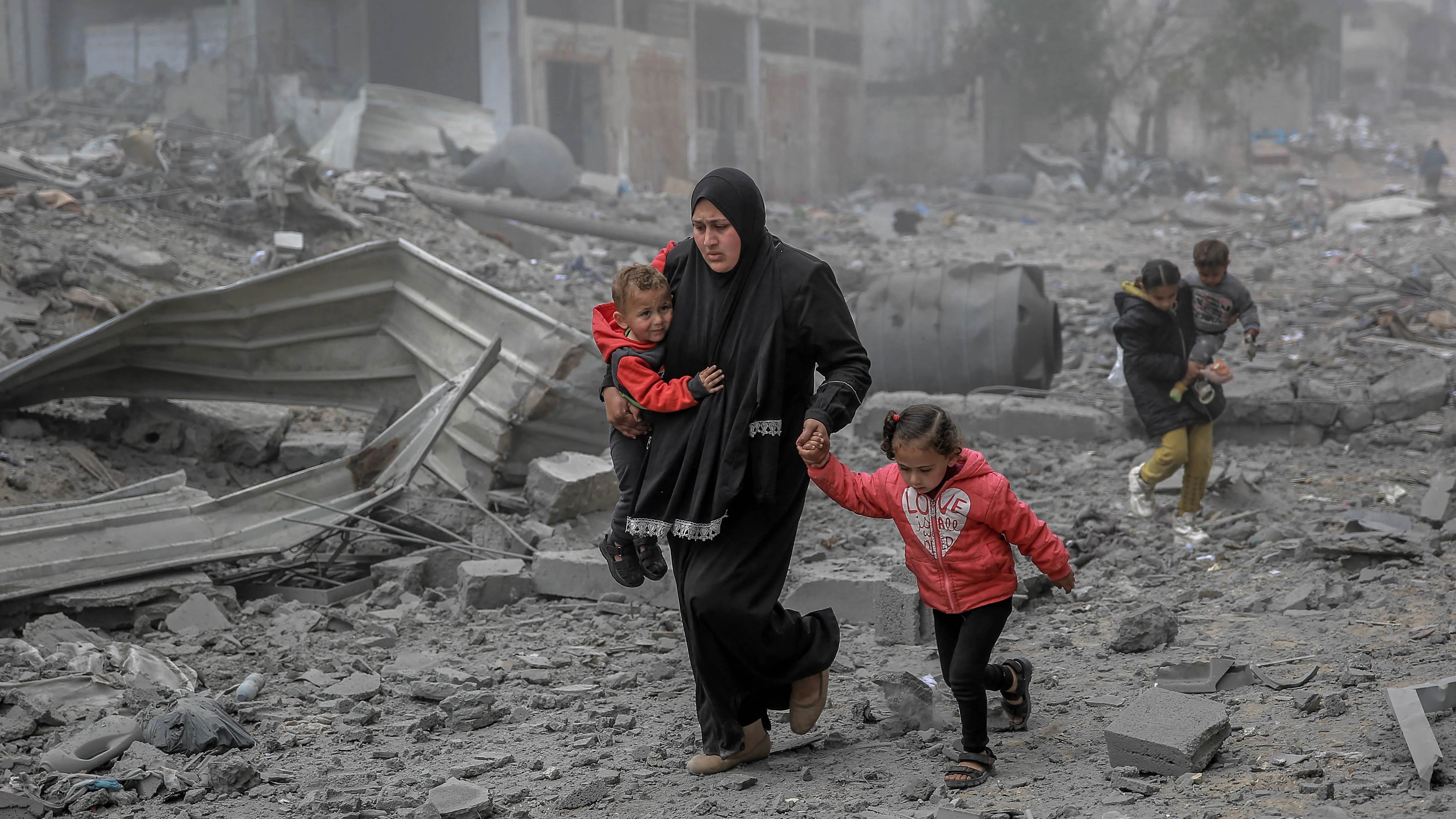 عائلة فلسطينية تغادر منزلها المدمر في غزة بعد قصف إسرائيلي