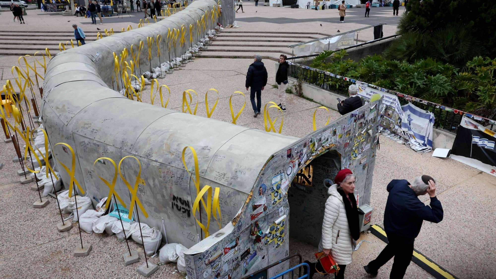 شخصان يخرجان من تجهيز فني على شكل نفق لإحياء ذكرى رهائن 7 تشرين الأول (أكتوبر) في باحة متحف تل أبيب للفنون