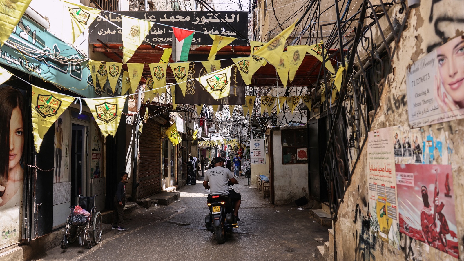 رجل يسير بدراجته النارية داخل أحد مخيمات اللجوء الفلسطيني في لبنان