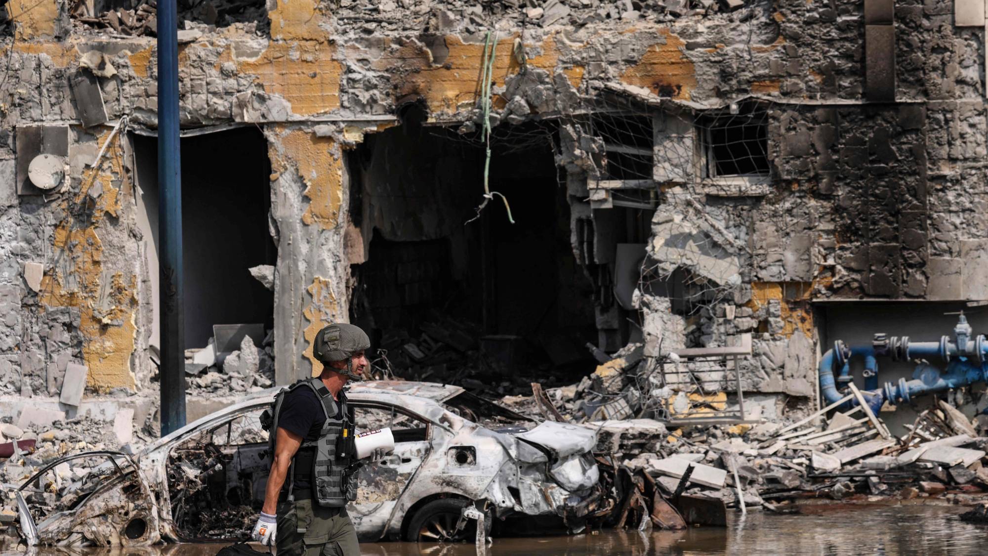 جندي إسرائيلي أمام مركز للشرطة تعرض لأضرار خلال معارك لطرد مقاتلي «حماس» الذين كانوا متمركزين داخله في أكتوبر 2023