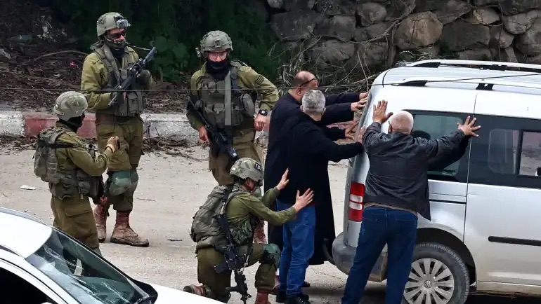 جنود إسرائيليون يعتقلون رجالاً فلسطينيين خلال مداهمة في أحد مخيمات اللاجئين في الضفة الغربية المحتلة