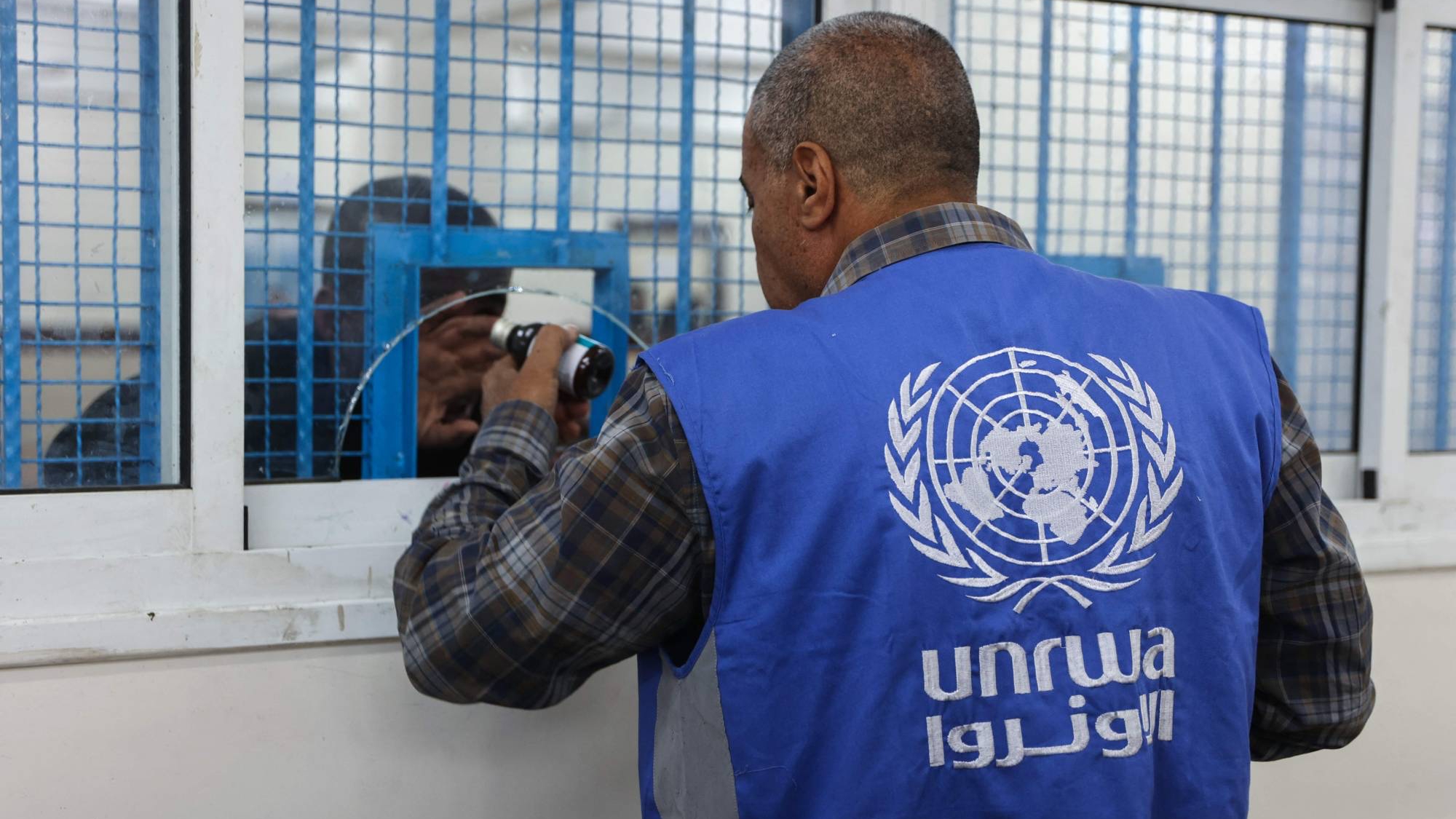 موظف يوزع الأدوية في عيادة تديرها «الأونروا» بمخيم الشاطئ للاجئين غرب مدينة غزة