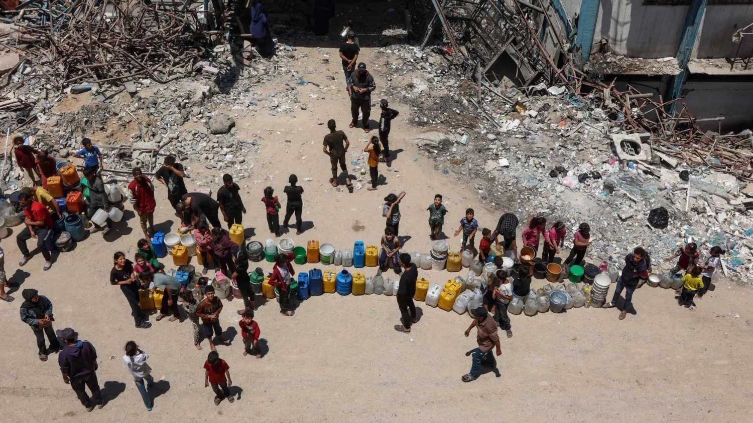 فلسطينيون يصطفون لملء حاوياتهم بالمياه في حي الرمال بمدينة غزة