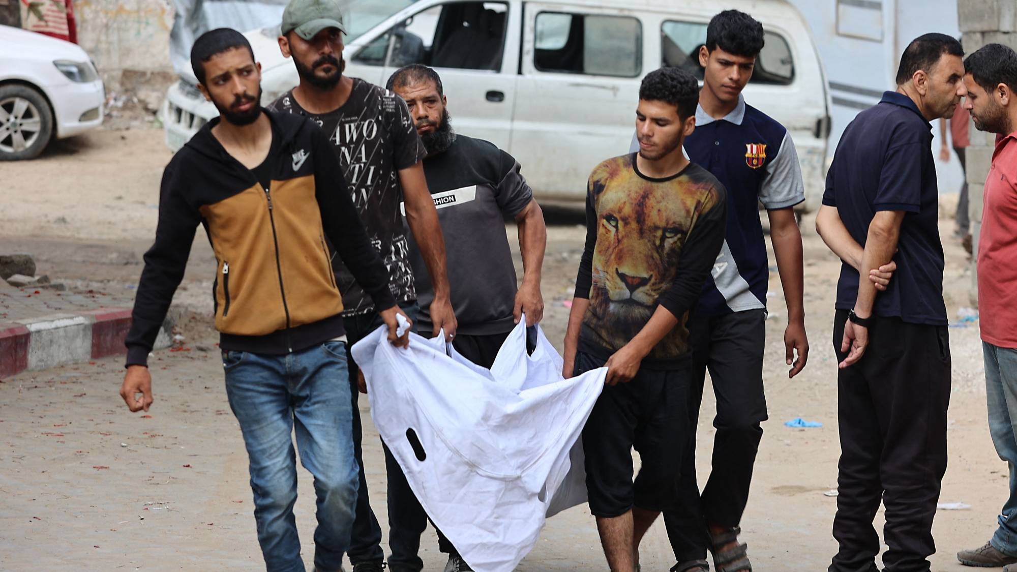 فلسطينيون يحملون جثمان شخص يوم الثلاثاء قالوا إنه قُتل خلال محاولته الحصول على مساعدة غذائية قرب معبر تسيطر عليه إسرائيل