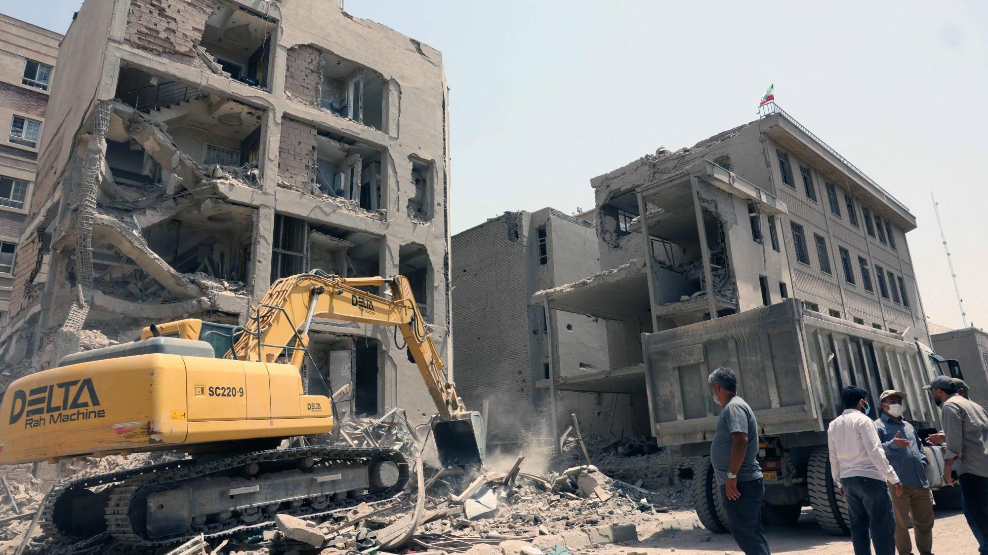 حفارة تزيل الأنقاض أمام مبنى تعرض مؤخراً لضربات إسرائيلية في طهران