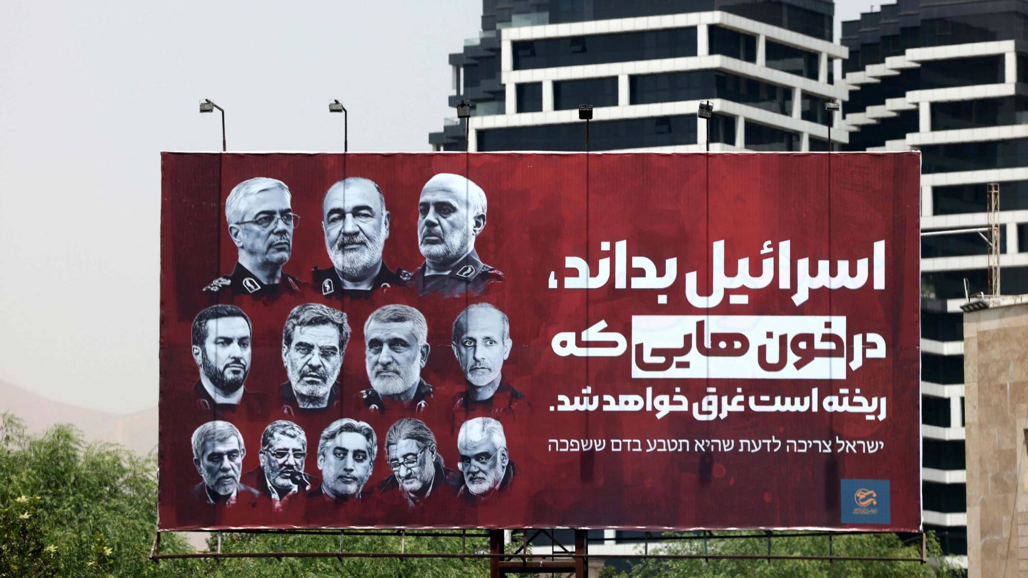 لوحة دعائية تعرض في أحد شوارع طهران تحمل صور عدد من كبار القادة العسكريين الإيرانيين الذين قتلوا في الهجمات الأخيرة وتتوعد إسرائيل بالانتقام